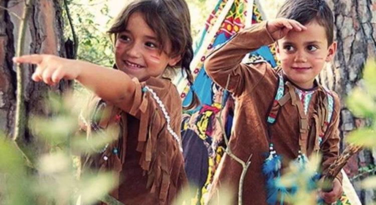 Niños disfrazados de indígenas en un bosque