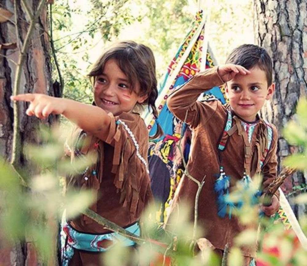 Niños disfrazados de indígenas en un bosque